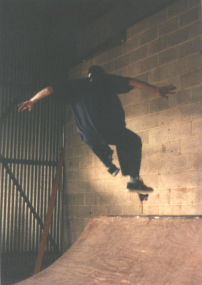 Terry Jacks popping a big frontside kickflip on the quarter-pipe at the Tarrant warehouse